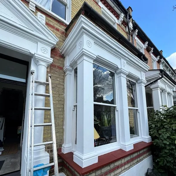 Victorian terraced house with painted stucco facade and bay window restoration, London